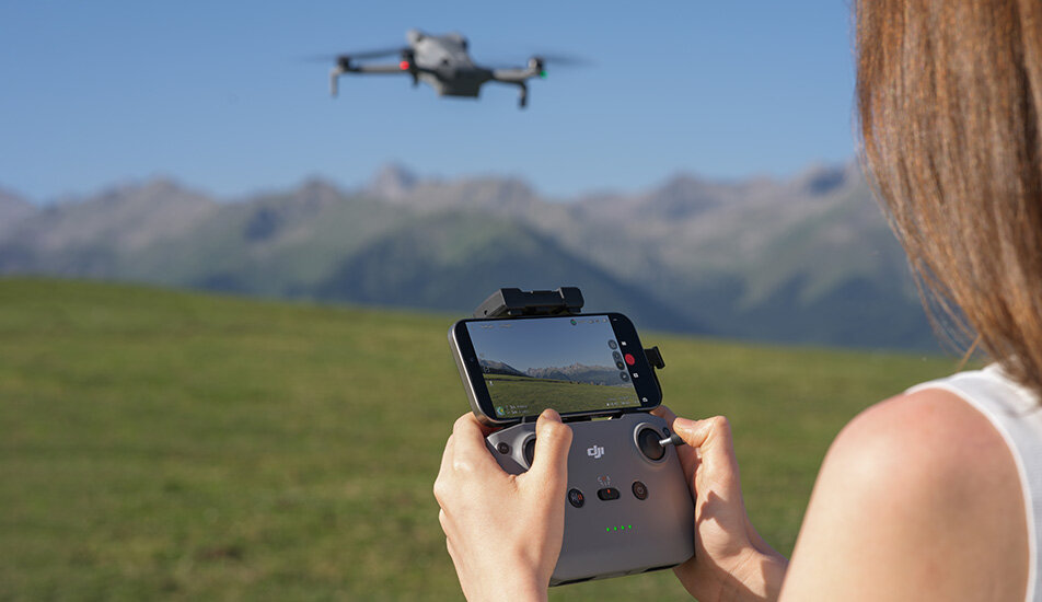 Kobieta sterująca dronem DJI Mini 5 Pro.
