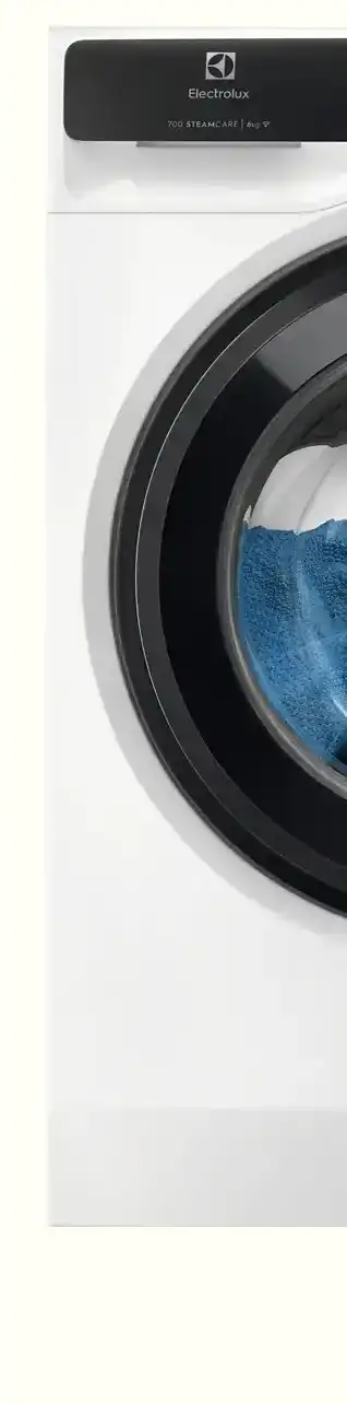 Fragment pralki z widocznym panelem z logo Electrolux i napisem \'700 SteamCare 9 kg\'. W bębnie znajduje się niebieski ręcznik.