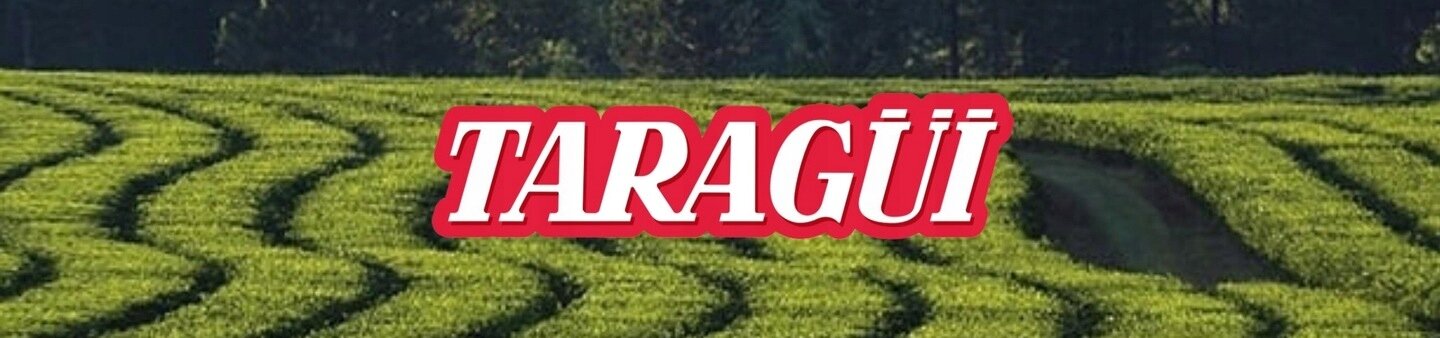 Na obrazie widoczne są zielone pola uprawne z logo \'TARAGÜI\' na pierwszym planie.