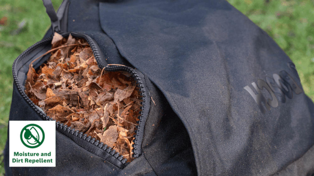 Czarna torba z zamkiem błyskawicznym, wypełniona suchymi liśćmi. Widoczne logo \'Bosch\' oraz ikona z napisem \'Moisture and Dirt Repellent\'.