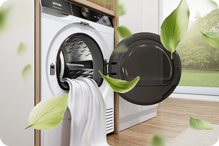 Otwarta suszarka Gorenje z wysuwającą się z bębna białą tkaniną i unoszącymi się zielonymi liśćmi.