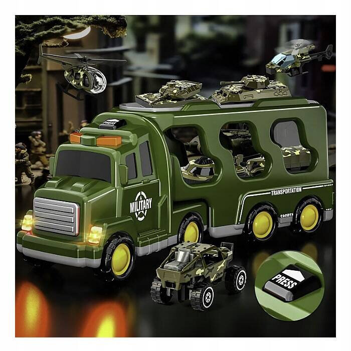 Zielony transporter wojskowy z napisem \'MILITARY\' i \'TRANSPORTATION\', na którym znajdują się miniaturowe pojazdy wojskowe i helikoptery. W prawym dolnym rogu widoczny jest przycisk z napisem \'PRESS\'.