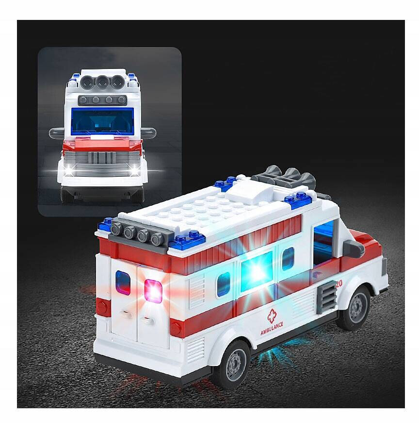 Zabawka w kształcie karetki pogotowia z otwieranymi drzwiami, posiadająca czerwono-białe barwy i świecące światła. Na boku widoczny jest napis \'AMBULANCE\'.