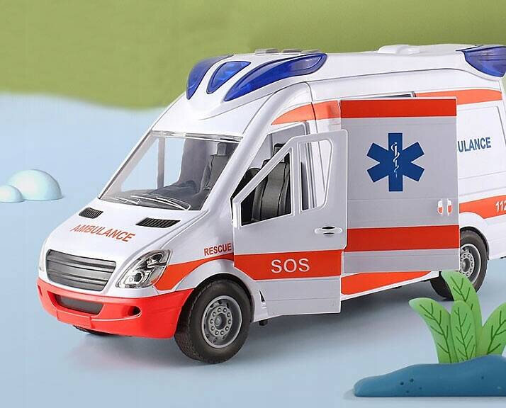 Zabawka w kształcie karetki pogotowia z otwartymi drzwiami, w kolorze białym z czerwonymi i niebieskimi elementami. Na boku widoczne napisy: \'AMBULANCE\', \'RESCUE\', \'SOS\'.