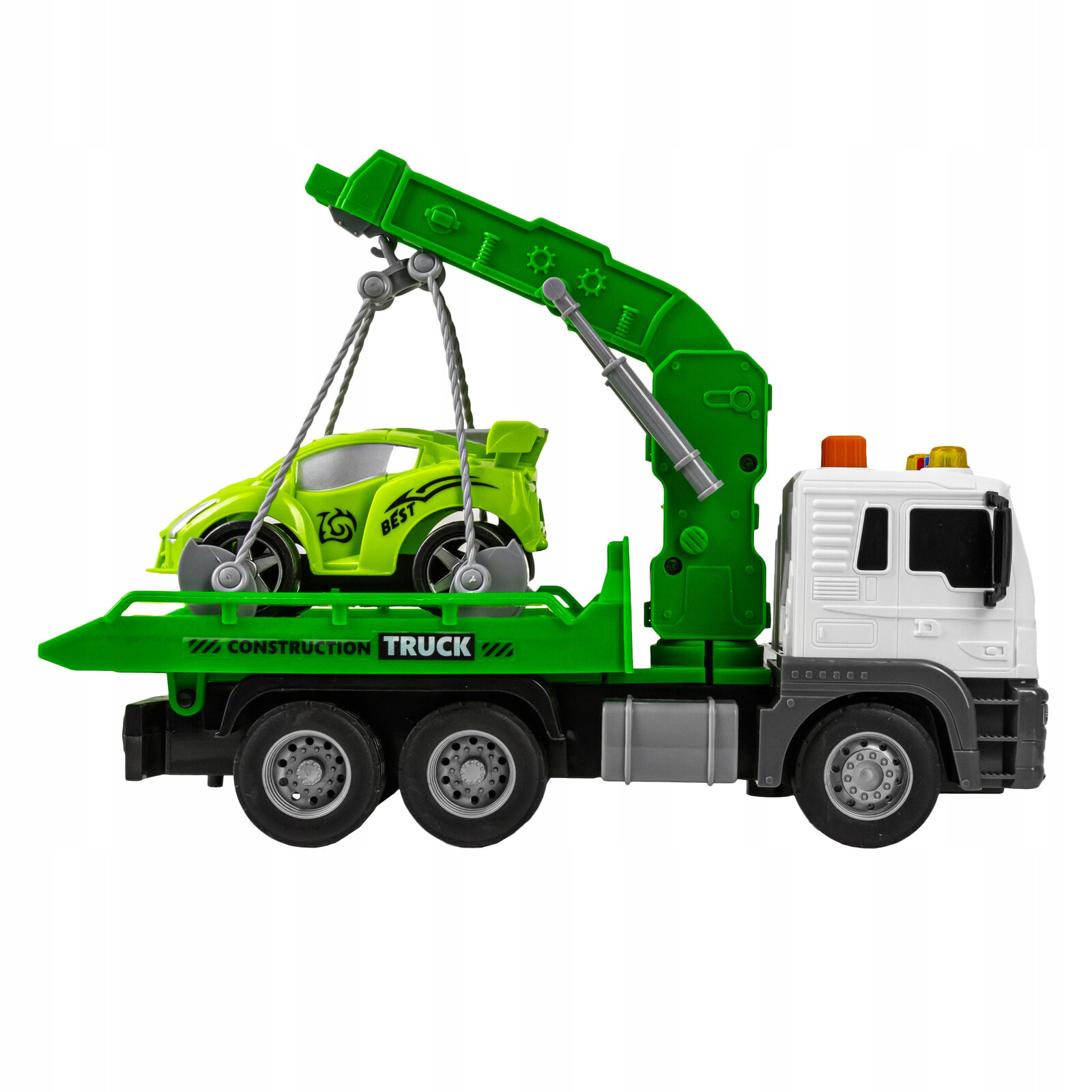 Zabawka holownik z ruchomą naczepą w kolorze zielonym i białym, z podwieszonym małym, zielonym autkiem z napisem \'BEST\'. Na naczepie widoczny jest napis \'CONSTRUCTION TRUCK\'.