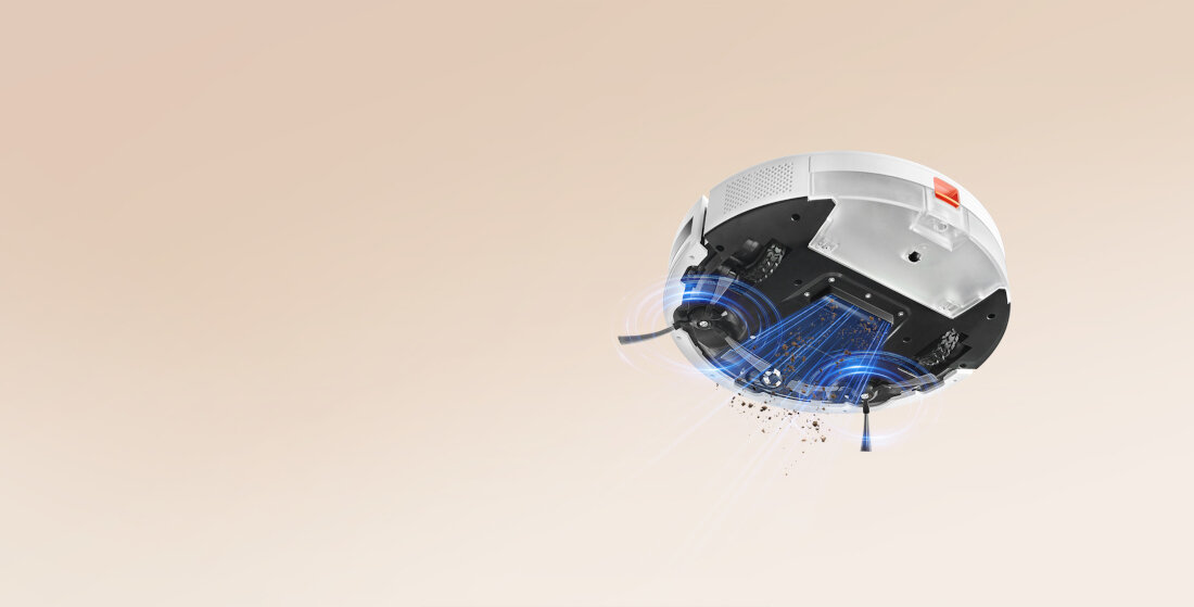 Biały robot sprzątający z widocznymi szczotkami i otworami wylotowymi. W tle jednolite, jasne tło.