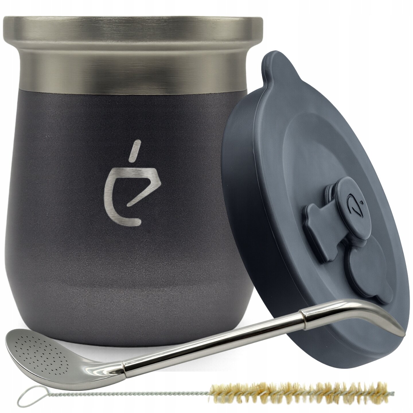 Na obrazie widoczny jest zestaw do yerba mate składający się z ciemnoszarego matero z metalowym brzegiem, pokrywki, metalowej bombilli oraz szczoteczki do czyszczenia. Na matero znajduje się logo w kształcie stylizowanej litery \'é\'.