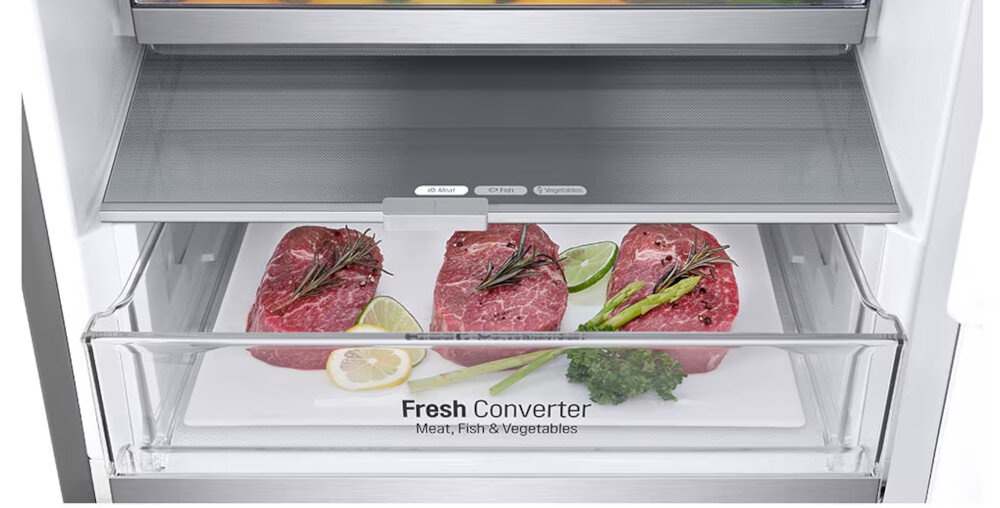 Wnętrze lodówki z szufladą oznaczoną jako \'Fresh Converter Meat, Fish & Vegetables\', w której znajdują się kawałki mięsa, plasterki cytryny, limonki oraz gałązki ziół. Szuflada jest przezroczysta, a nad nią znajduje się półka.
