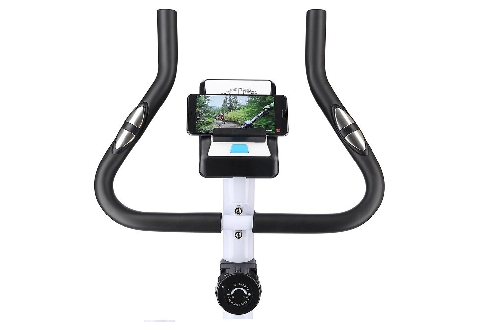 Kierownica roweru magnetycznego z uchwytem na telefon, na którym wyświetlany jest obraz z trasy rowerowej. Poniżej znajduje się pokrętło z oznaczeniami poziomów oporu.