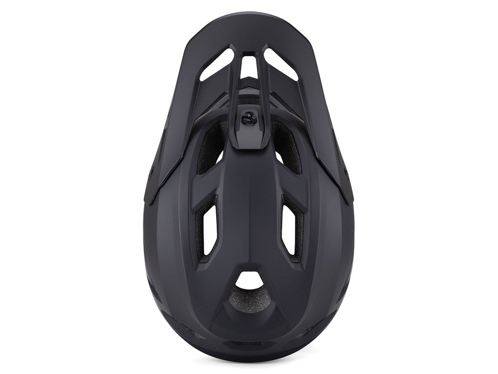 Czarny kask rowerowy typu full face z kilkoma otworami wentylacyjnymi, widziany z góry. Kask ma aerodynamiczny kształt i matowe wykończenie.