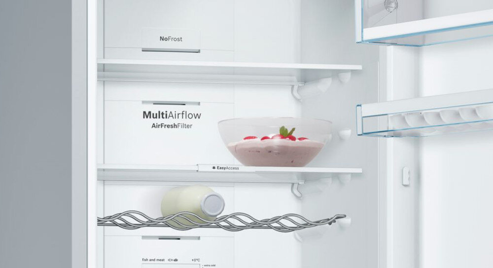 Wnętrze lodówki z półkami, na których znajdują się miska z deserem i butelka. Widoczne napisy: \'NoFrost\', \'MultiAirflow AirFreshFilter\', \'EasyAccess\'.