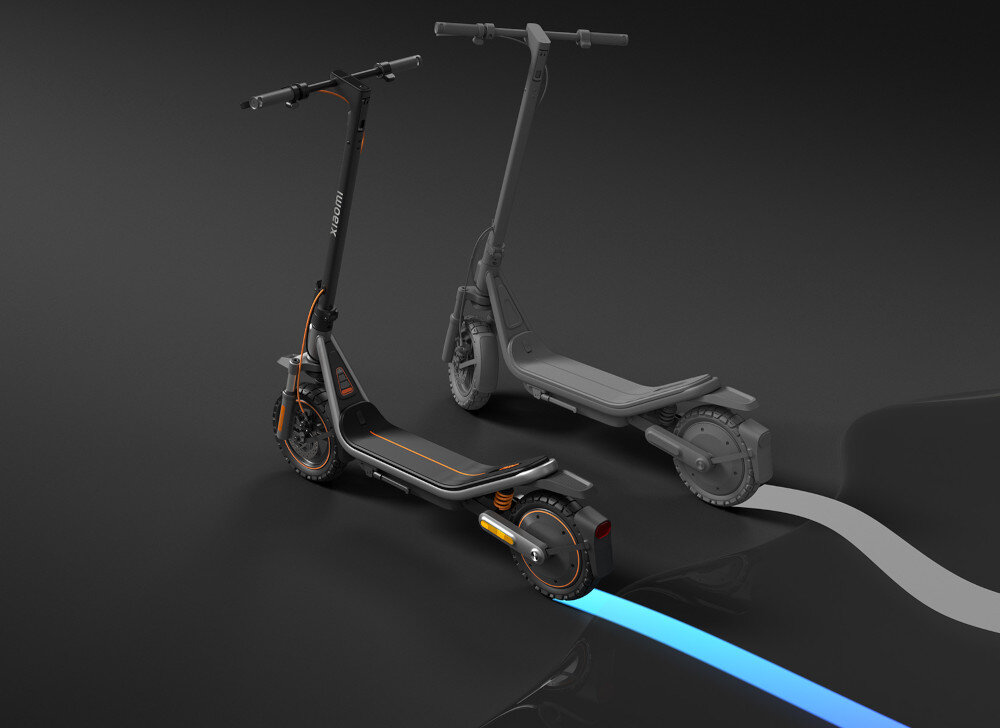 Na obrazie widoczna jest czarna hulajnoga elektryczna z pomarańczowymi akcentami i logo \'xiaomi\' na kierownicy. W tle znajduje się jej szary zarys, a na podłodze widoczne są kolorowe linie.