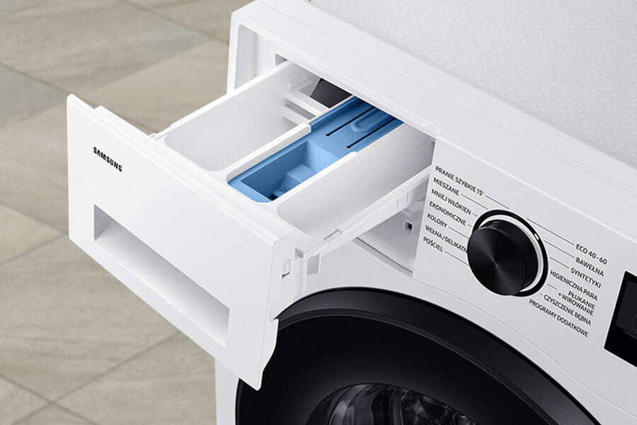 Szuflada StayClean pralki EcoBubble AI Energy marki Samsung Zdjęcie przedstawia otwarty dozownik na detergenty w pralce z widocznym logo \'SAMSUNG\'. Obok znajduje się pokrętło z różnymi programami prania, takimi jak \'ECO 40-60\', \'Bawełna\', \'Syntetyki\', \'Higieniczna Para\'.
