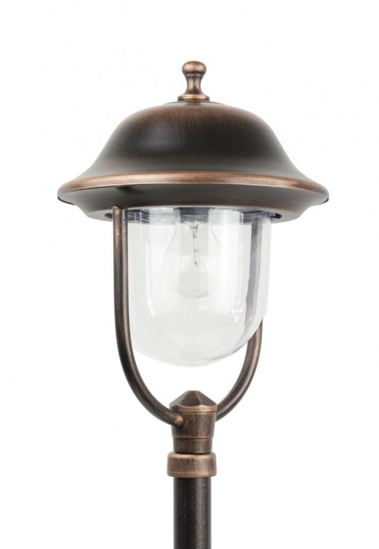 Lampa zewnętrzna stojąca w kolorze patyny miedzi z przezroczystym kloszem. Posiada dekoracyjny daszek i metalowe elementy konstrukcyjne.