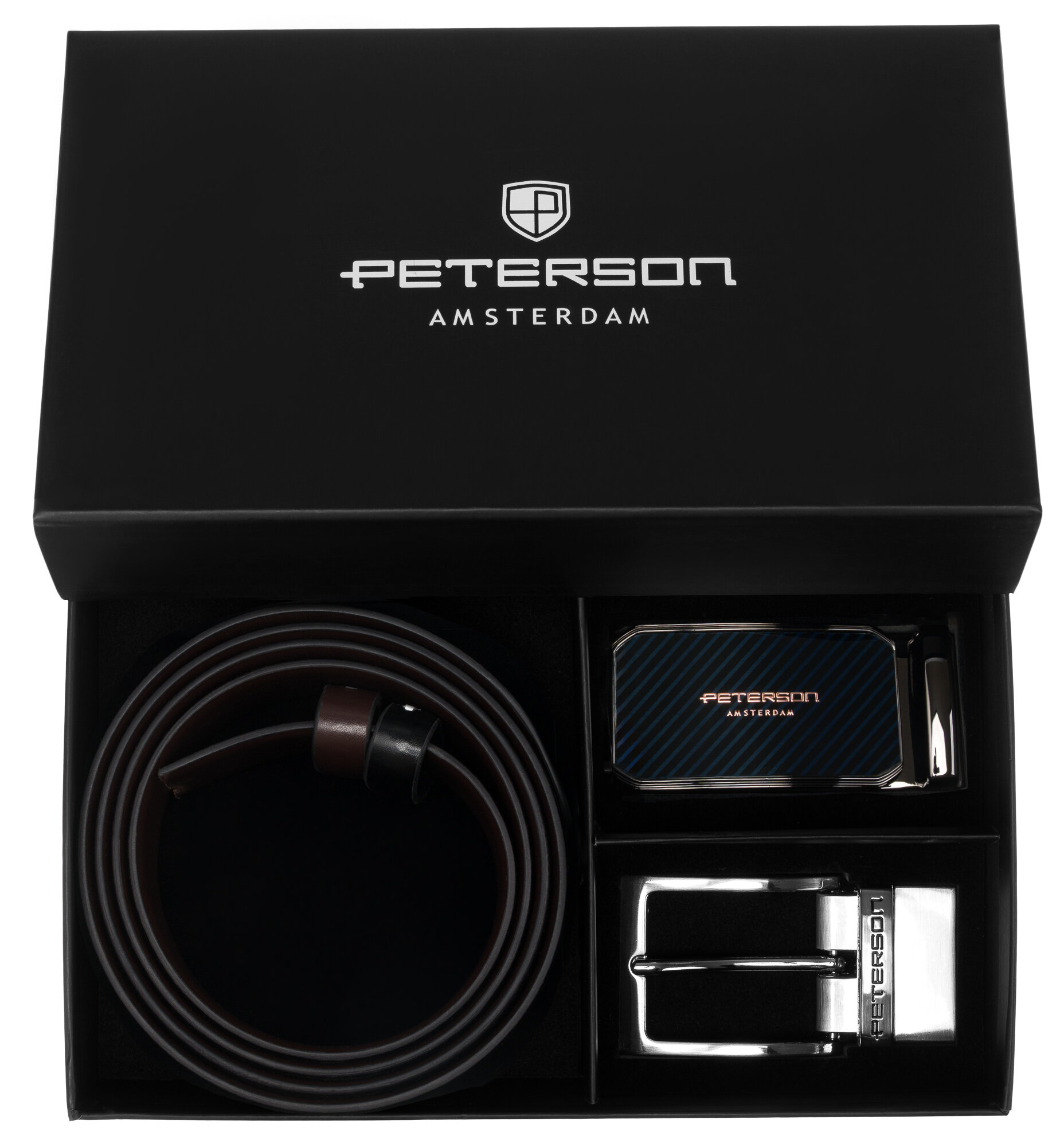 Czarny pudełko z logo \'PETERSON AMSTERDAM\' zawiera skórzany pasek w kolorze czarnym i ciemnobrązowym oraz dwie klamry. Jedna z klamr ma napis \'PETERSON\'.