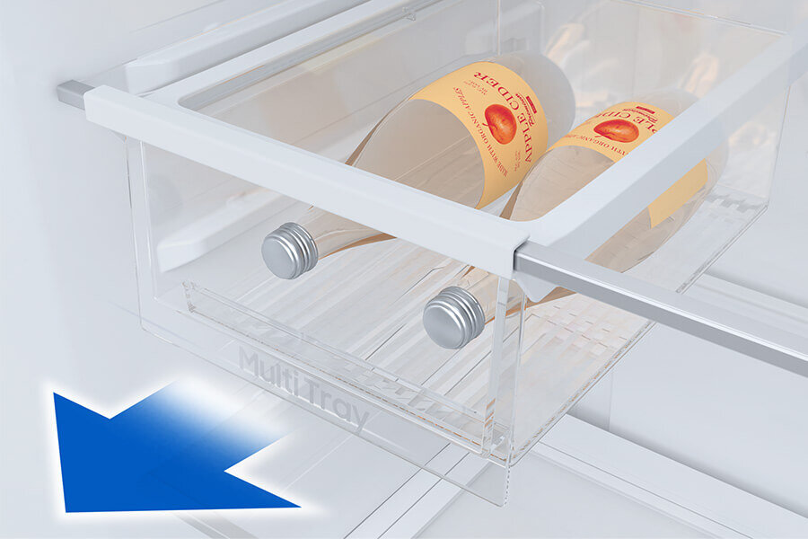 Wnętrze lodówki z przezroczystą szufladą oznaczoną napisem \'Multi Tray\', w której znajdują się dwie butelki z etykietami. W dolnym rogu widoczna jest niebieska strzałka skierowana w dół.