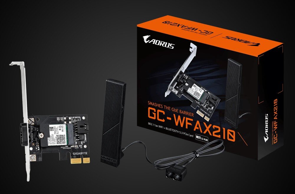 Komputer XQUANTUM XQR7R32S512GB-XA43WP karta sieciowa PCIe z modułem radiowym i śledziem metalowym, obok dwie anteny na kablach oraz pudełko z napisem 'GC-WFAX210' na ciemnym tle, karta sieciowa, pasma, łączność Bluetooth