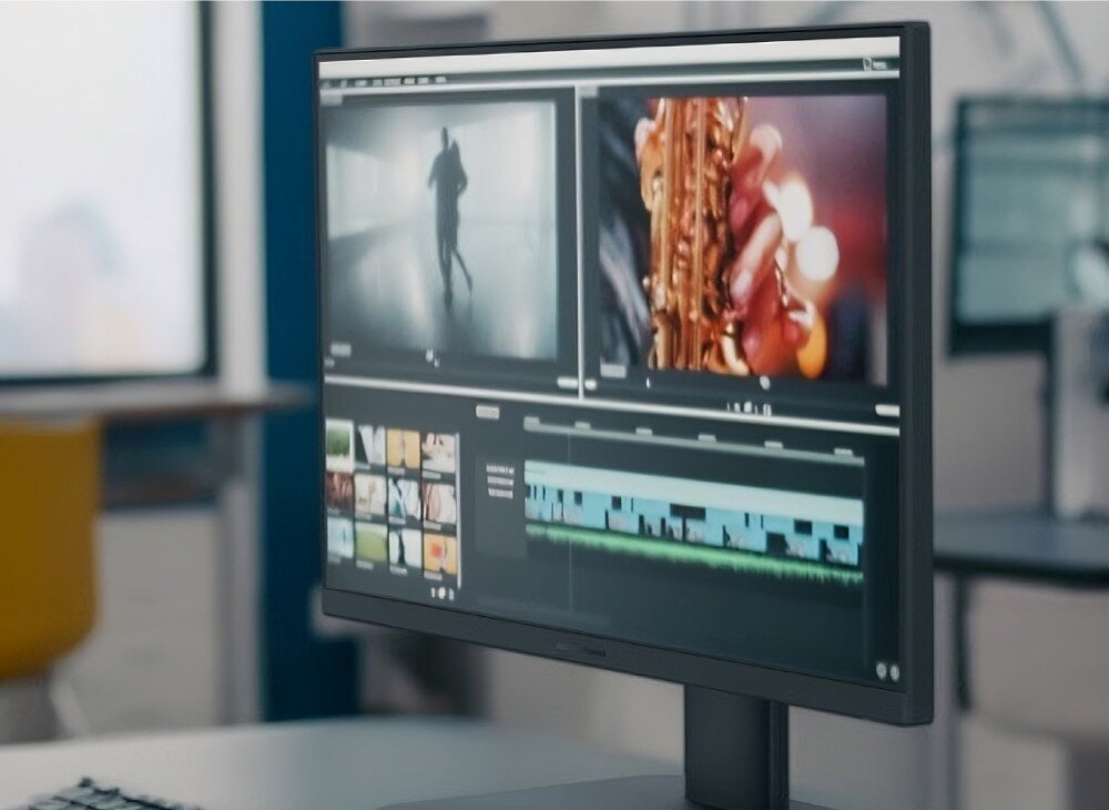 Komputer All in One ASUS V440VAT-BPD036W Widok z boku na czarny komputer stacjonarny stojący w biurze, na którego ekranie uruchomiony jest program do edycji wideo z widoczną osią czasu i podglądem klipów filmowych, ekran, rozdzielczość, ochrona wzroku