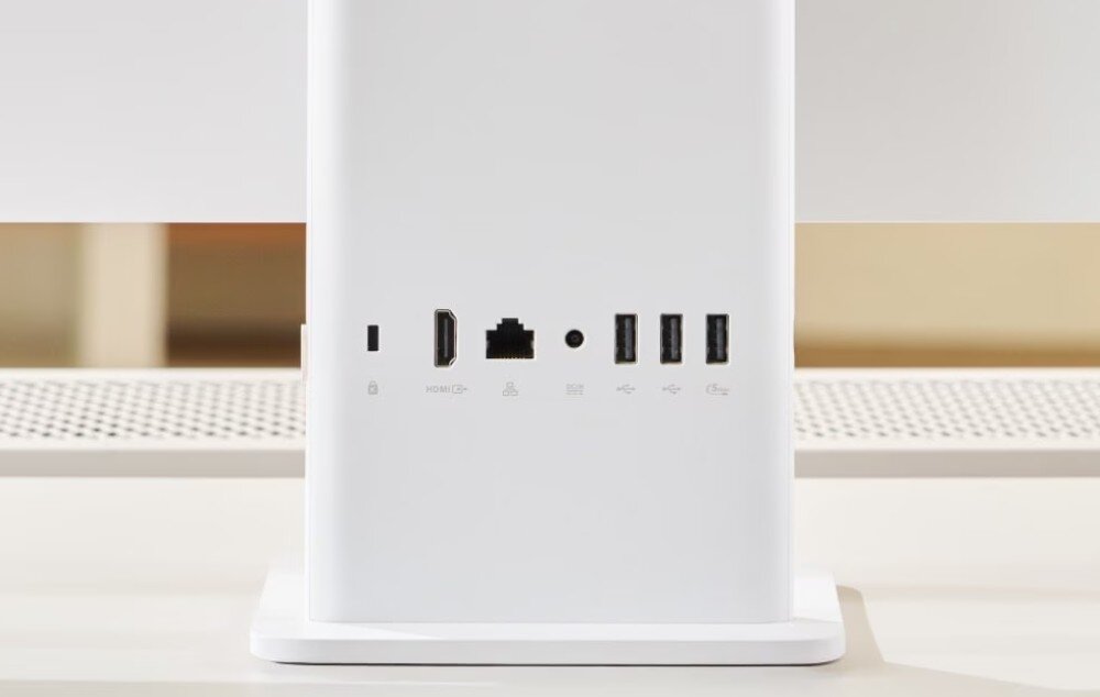 Biała tylna część monitora z widocznymi portami: HDMI, Ethernet, zasilanie, dwa porty USB i jeden port USB-C. Na podstawie monitora znajduje się perforowana powierzchnia.
