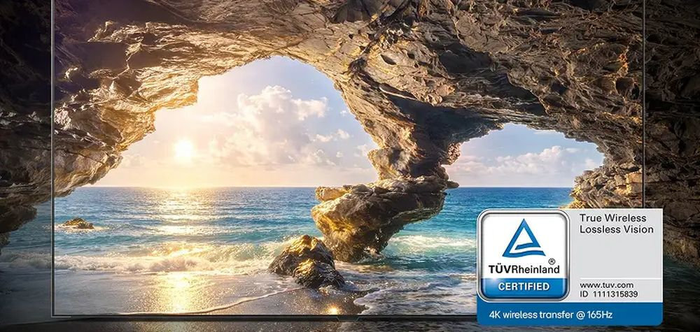 LG OLED83W69LA Bezprzewodowa transmisja obraz 4K częstotliwości odświeżania 165 Hz Niska latencja True Wireless Lossless Vision Ekran wyświetlający słoneczną plażę ze skalnym łukiem oraz ikonę certyfikatu bezprzewodowej transmisji.