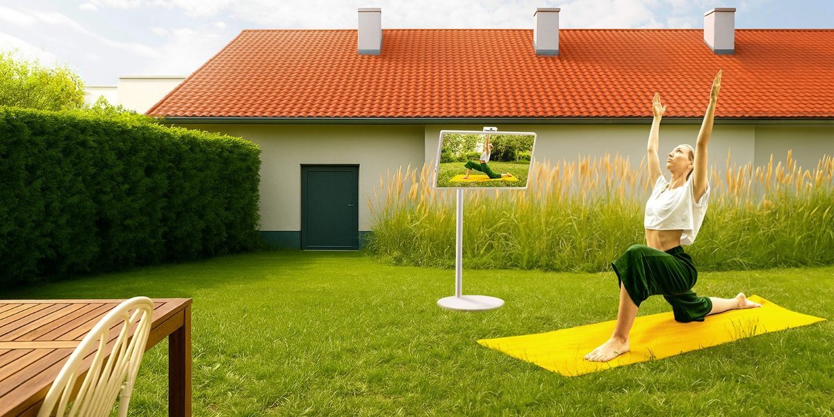 Kobieta ćwicząca na macie, obok kobiety widoczny jest telewizor LG z włączoną funkcją Smart Cam. 