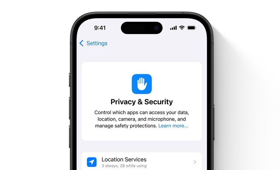 Na ekranie smartfona widoczna jest sekcja \'Privacy & Security\' z ikoną dłoni oraz tekstem: \'Control which apps can access your data, location, camera, and microphone, and manage safety protections. Learn more...\'.