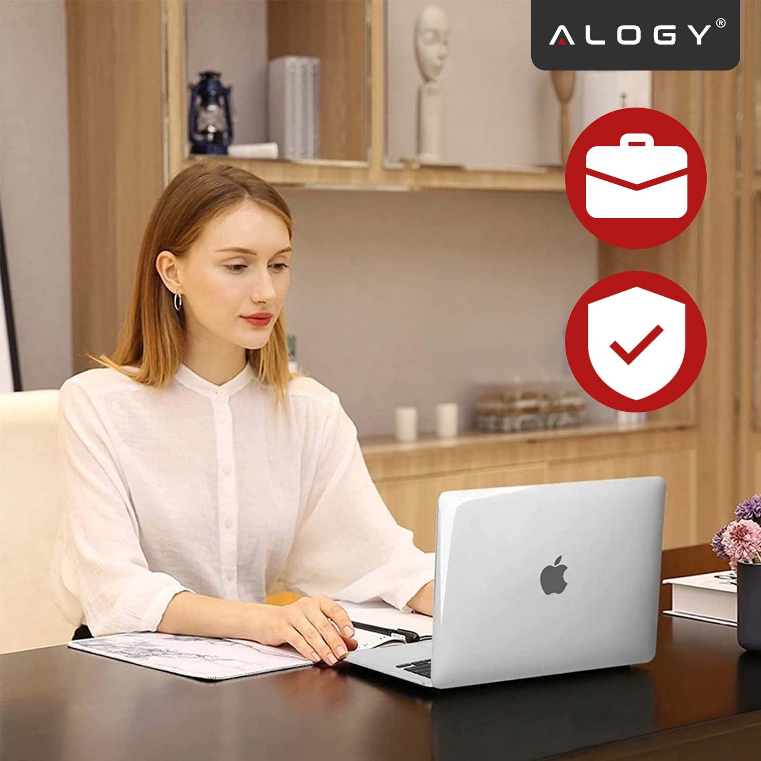 Kobieta siedzi przy biurku z otwartym laptopem, na którym widoczne jest logo w kształcie jabłka. W prawym górnym rogu znajduje się logo \'ALOGY\' oraz dwie czerwone ikony przedstawiające teczkę i tarczę z zaznaczeniem.