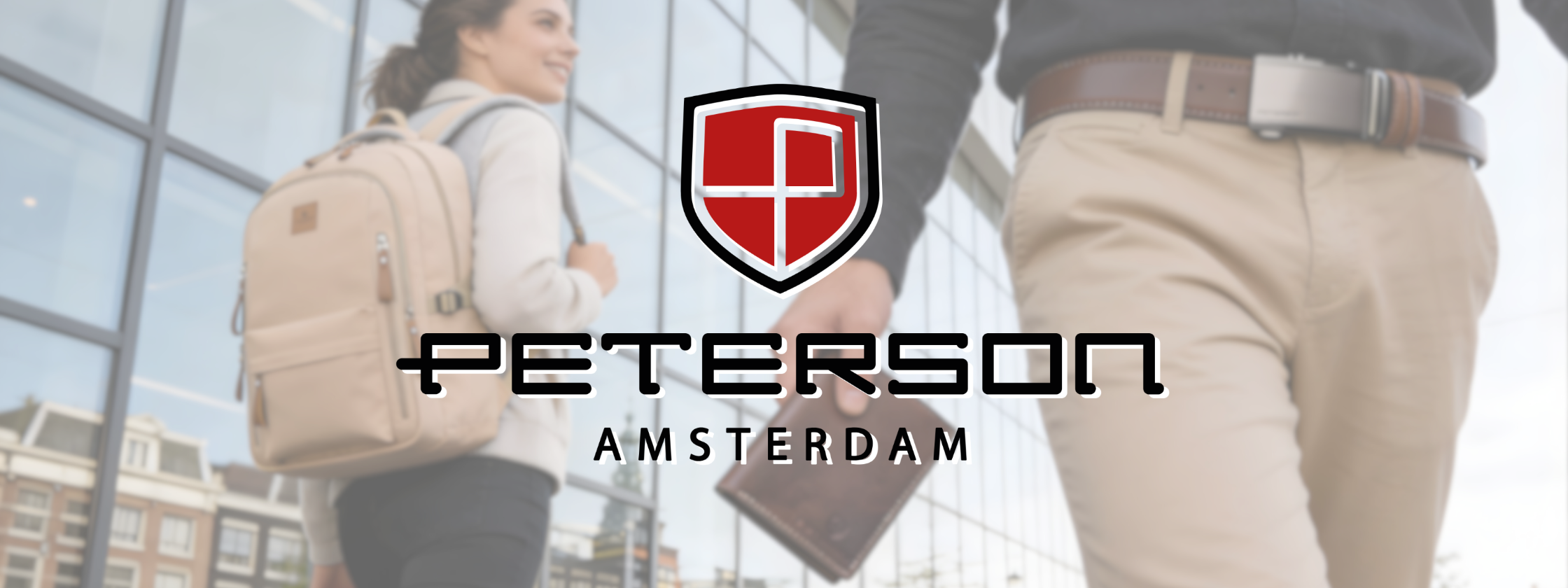 Na obrazie widoczne jest logo PETERSON z napisem AMSTERDAM na tle dwóch osób idących obok szklanej fasady budynku. Jedna z osób trzyma brązowy portfel, a druga ma beżowy plecak.