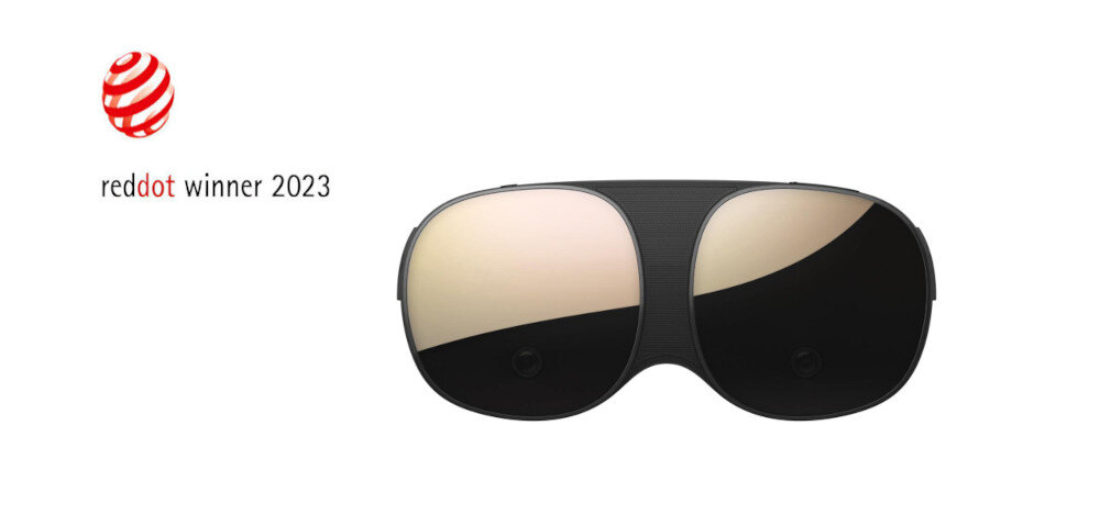 Obraz przedstawia gogle VR z ciemnymi szkłami i czarną oprawką. Po lewej stronie widnieje logo \'reddot winner 2023\'.