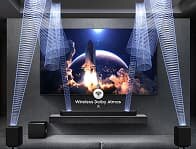 Na obrazie znajduje się zestaw kina domowego z telewizorem wyświetlającym start rakiety na tle planety. Widoczne są głośniki i subwoofer, a na ekranie napis \'Wireless Dolby Atmos\'.