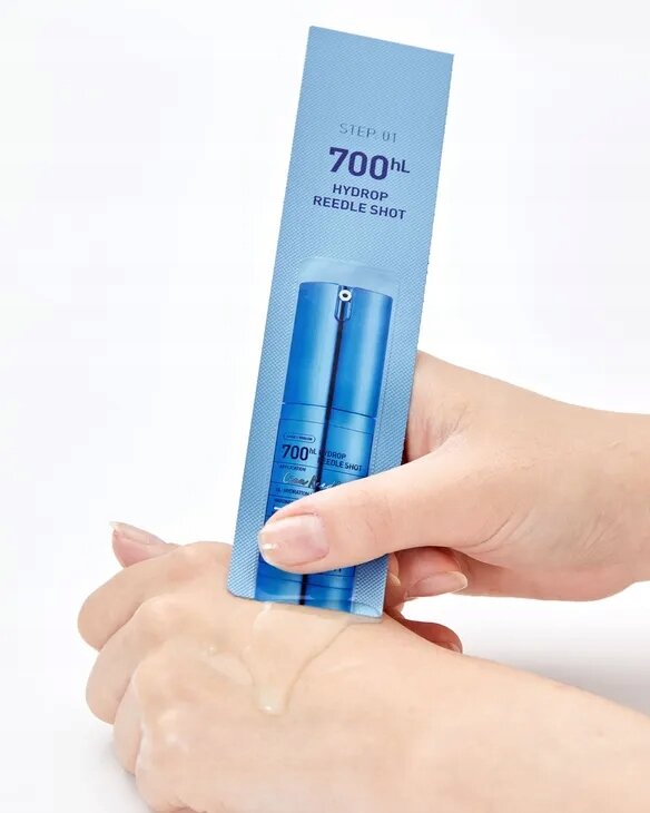 Osoba trzyma niebieskie opakowanie z napisem \'STEP 01 700 hL HYDROP REEDLE SHOT\' nad dłonią, na której znajduje się przezroczysty żel.