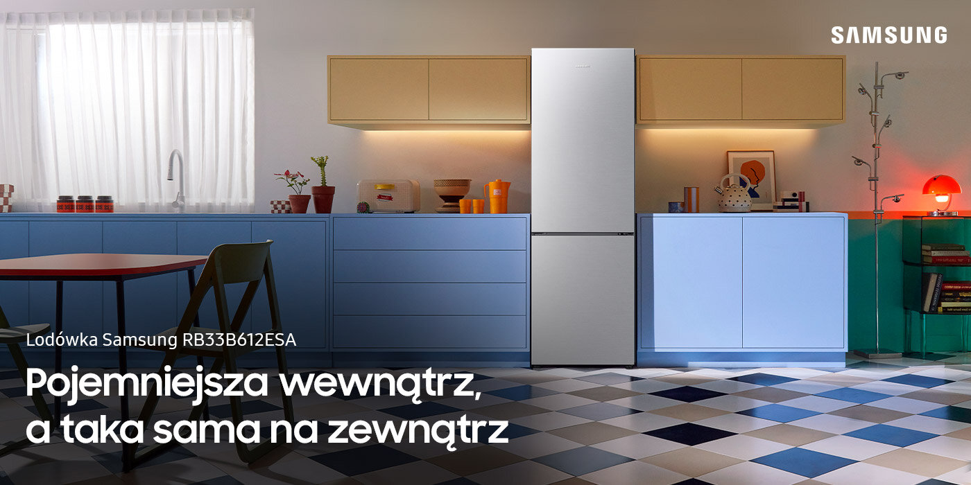 Zdjęcie pokazuje lodówkę Samsung RB33B612ESA z oferty Media Expert w nowocześnie urządzonej kuchni Kuchnia z lodówką w centrum, otoczona niebieskimi szafkami i drewnianymi półkami. Na dole widoczny tekst: \'Lodówka Samsung RB33B612ESA Pojemniejsza wewnątrz, a taka sama na zewnątrz\'.