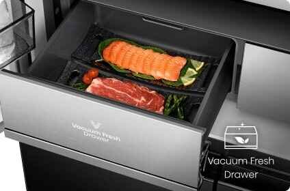 Otwarta szuflada lodówki z napisem \'Vacuum Fresh Drawer\', w której znajdują się kawałki łososia i mięsa na liściach sałaty. Obok szuflady widoczny jest symbol i napis \'Vacuum Fresh Drawer\'.
