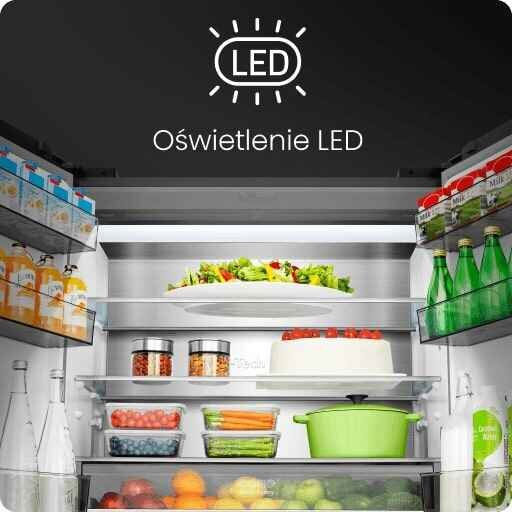 Wnętrze lodówki z oświetleniem LED, wypełnione różnorodnymi produktami spożywczymi, takimi jak napoje, warzywa i słoiki. Na górze widoczny jest napis \'Oświetlenie LED\'.