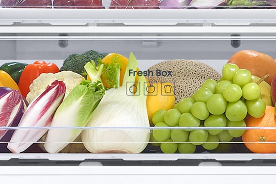 Fresh Box - Samsung RB53DG703DS9 - Media Expert W lodówce znajduje się szuflada oznaczona napisem \'Fresh Box\', wypełniona różnymi warzywami i owocami, takimi jak winogrona, sałata, brokuły i melon.