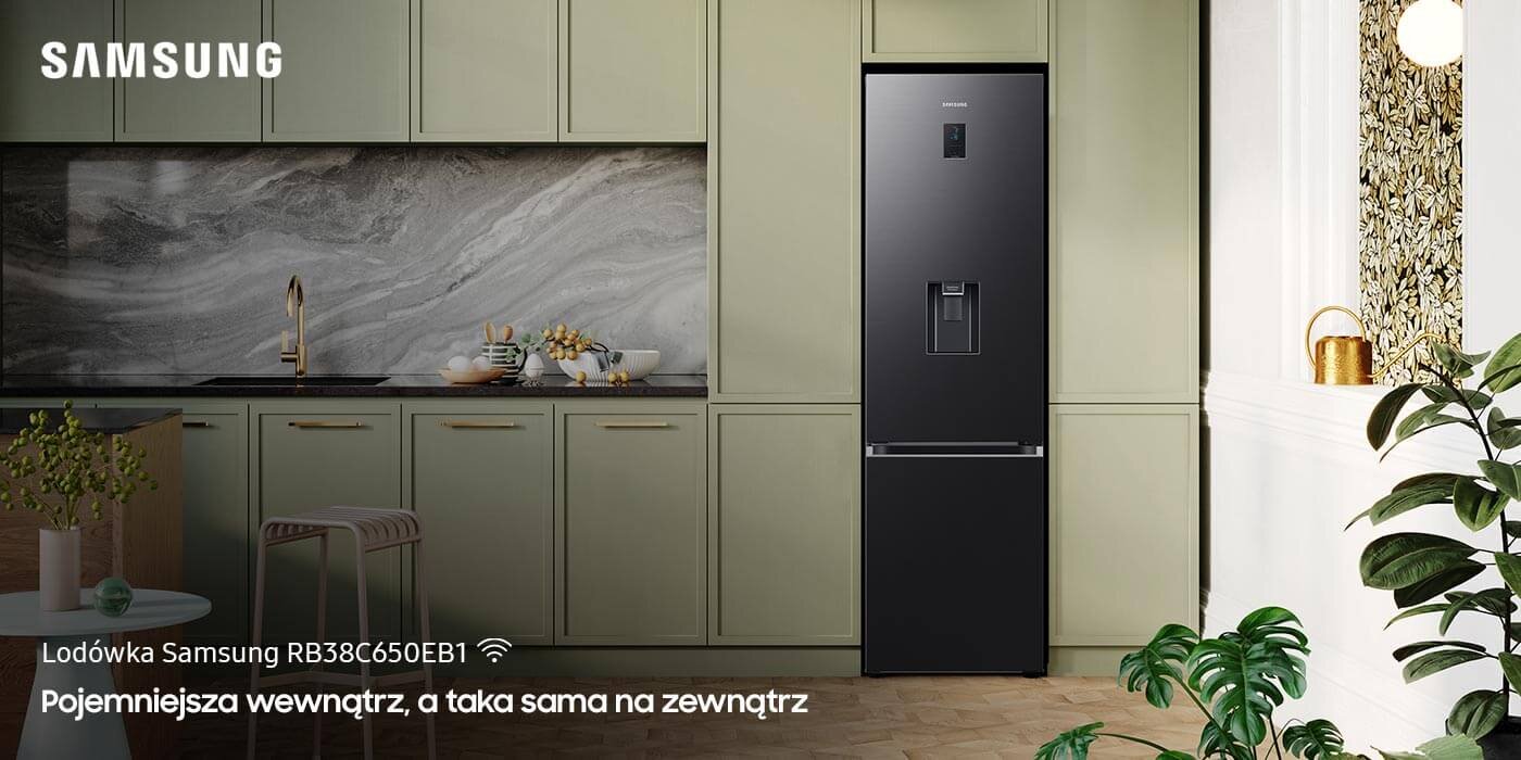 Lodówka Samsung Grand+ RB38C650EB1 z dystrybutorem wody W kuchni znajduje się czarna lodówka z logo Samsung, otoczona jasnymi szafkami. Na dole obrazu widnieje tekst: \'Lodówka Samsung RB38C774DB1 Pojemniejsza wewnątrz, a taka sama na zewnątrz\'.