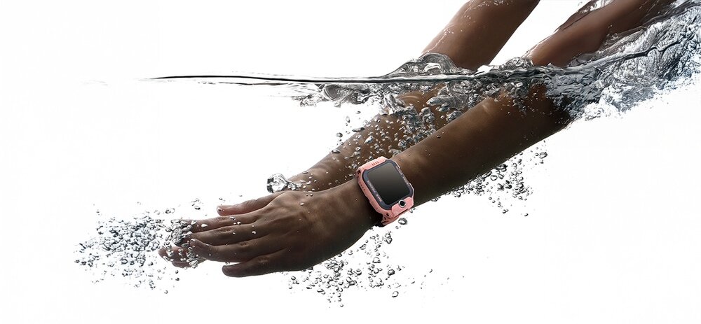Dwie ręce zanurzone w wodzie, na jednej z nich znajduje się smartwatch w różowej obudowie.