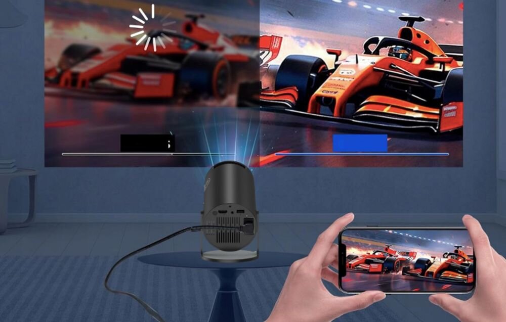 Obraz przedstawia projektor wyświetlający na ścianie dynamiczną scenę z wyścigami samochodowymi. Osoba trzyma smartfon, na którym widoczny jest ten sam obraz co na ścianie.