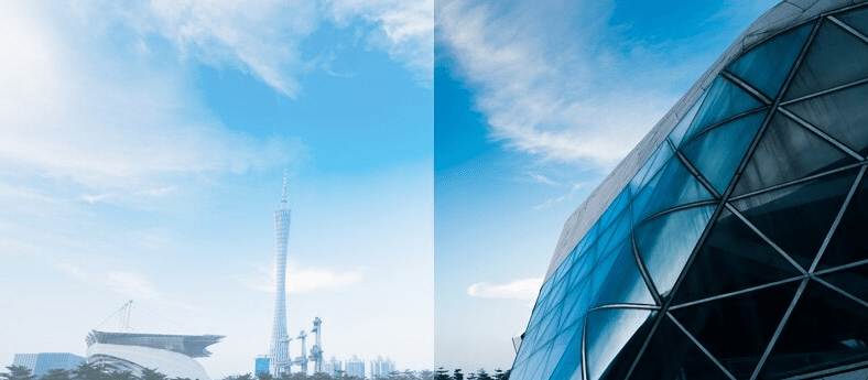 Obraz przedstawia panoramę miasta z wysoką wieżą i nowoczesnym budynkiem o szklanej fasadzie. Niebo jest jasne z niewielką ilością chmur.