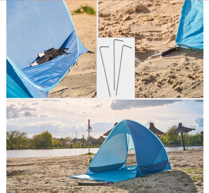 Na obrazie widoczny jest niebieski namiot plażowy rozstawiony na piaszczystej plaży, z widocznym okienkiem wentylacyjnym. Obok namiotu leżą metalowe szpilki do mocowania, a w tle widać wodę i drzewa.