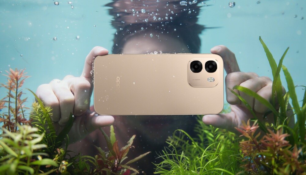 Osoba trzyma smartfon pod wodą, otoczona roślinami wodnymi. Na obudowie telefonu widoczne jest logo \'oppo\'.