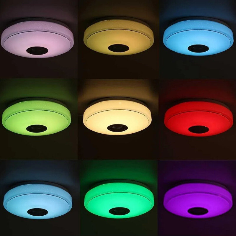 Obraz przedstawia dziewięć okrągłych lamp sufitowych, każda świecąca w innym kolorze: biały, żółty, niebieski, zielony, czerwony, jasnoniebieski, jasnozielony, fioletowy i różowy. Lampy mają centralny, ciemny element, prawdopodobnie głośnik.