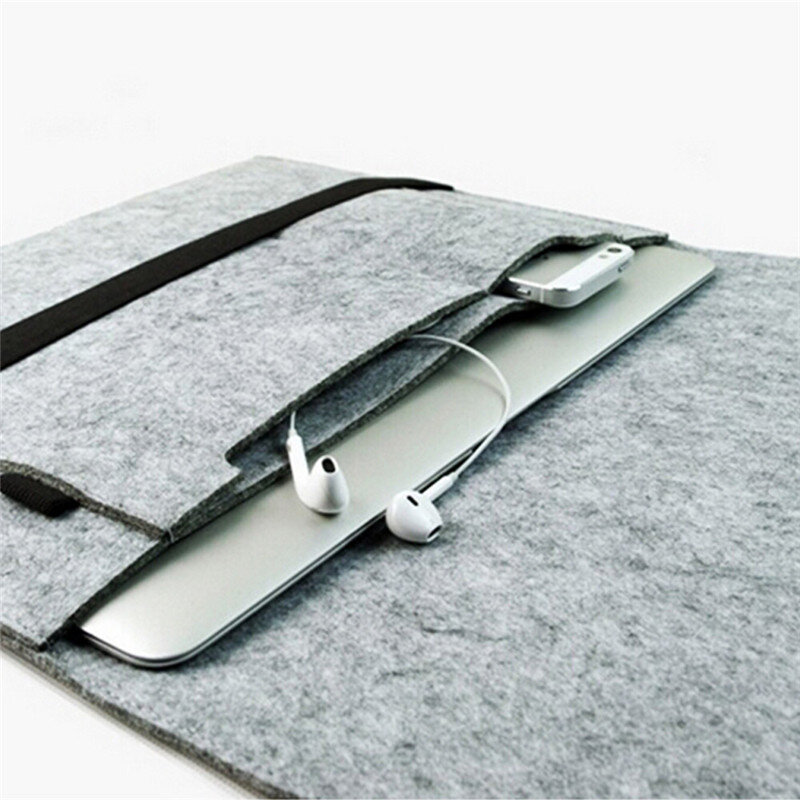Szare filcowe etui na laptopa z kieszenią, w której znajduje się laptop, telefon i słuchawki. Etui ma prosty design i jest otwarte, ukazując zawartość.