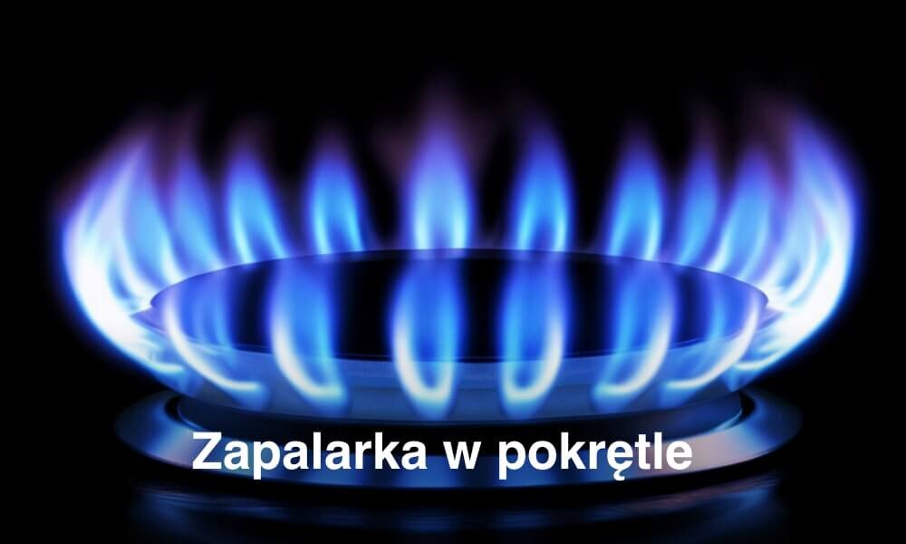 Obraz przedstawia płomień gazowy na palniku z niebieskimi płomieniami. Na dole widoczny jest tekst: \'Zapalarka w pokrętle\'.