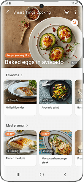 Interfejs aplikacji SmartThings Cooking z przepisem na \'Baked eggs in avocado\'. Widoczne są również sekcje \'Favorites\' z daniami \'Grilled flounder\' i \'Avocado salad\' oraz \'Meal planner\' z \'French meat pie\' i \'Moroccan hamburger steak\'.