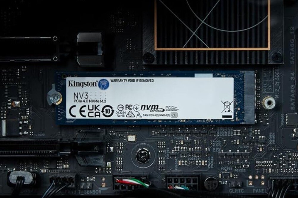 Na obrazie widoczny jest dysk Kingston NV3 PCIe 4.0 NVMe M.2 zamontowany na płycie głównej komputera. Na etykiecie znajdują się oznaczenia CE, UKCA, RoHS oraz logo producenta Kingston.