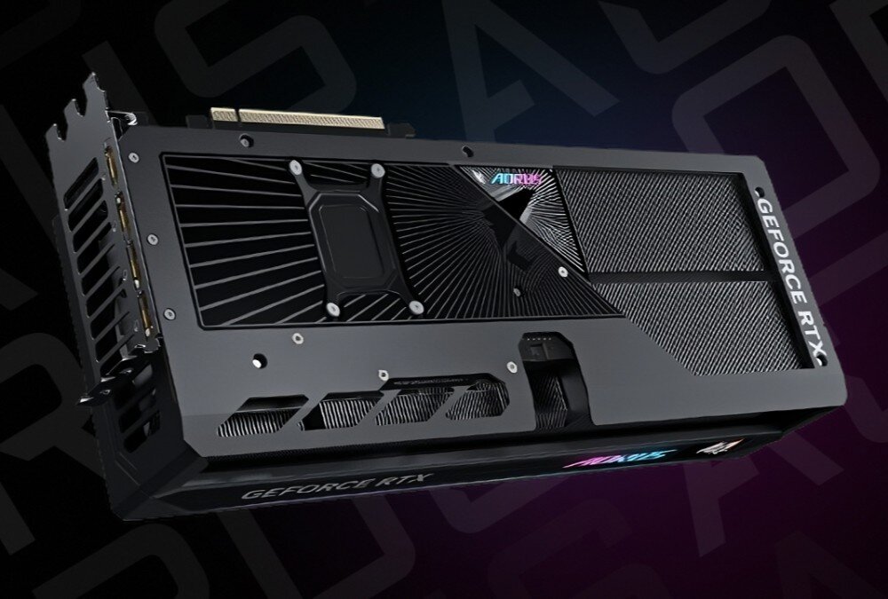 Obraz przedstawia kartę graficzną z widocznym napisem \'AORUS\' oraz \'GEFORCE RTX\'. Karta ma czarną obudowę z elementami wentylacyjnymi i metalicznymi akcentami.