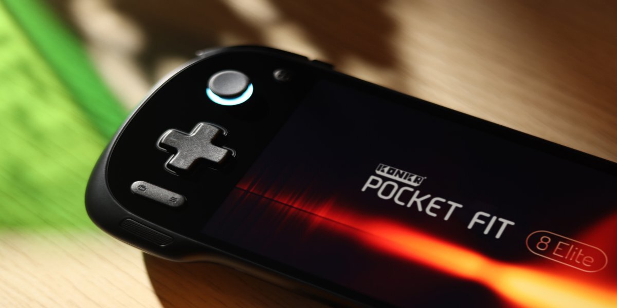 Na obrazie widoczna jest czarna konsola do gier z wyświetlaczem, na którym znajduje się napis \'KONKR POCKET FIT 8 Elite\'. Konsola posiada krzyżakowy przycisk i okrągły przycisk z podświetleniem.