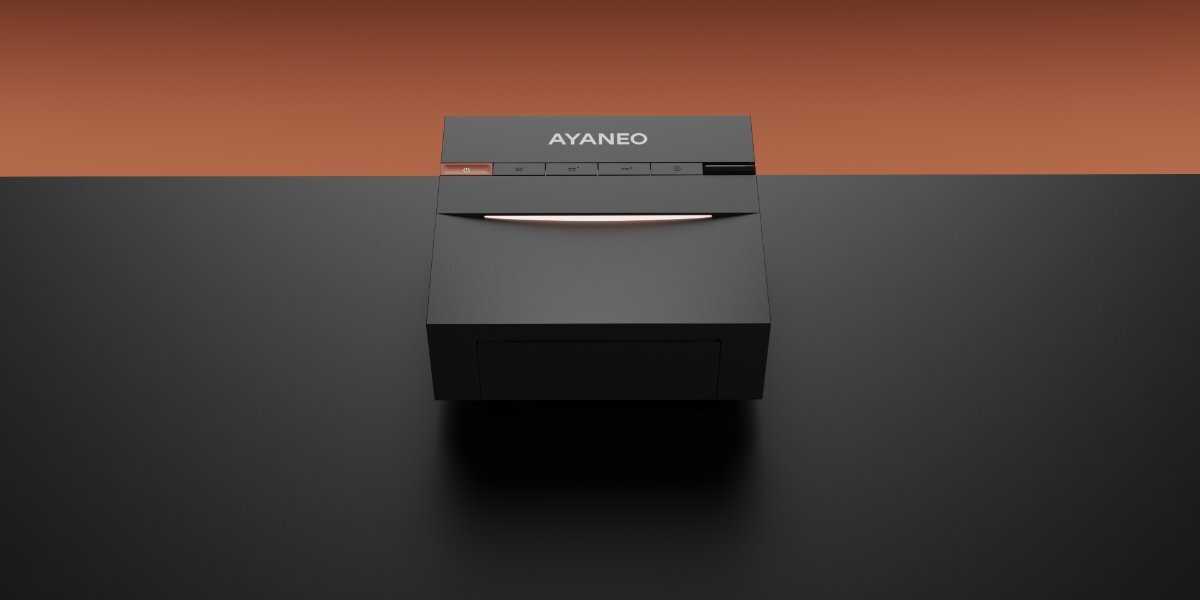 Czarny mini PC z widocznym logo \'AYANEO\' na górnej części obudowy, umieszczony na ciemnym tle z pomarańczowym gradientem.
