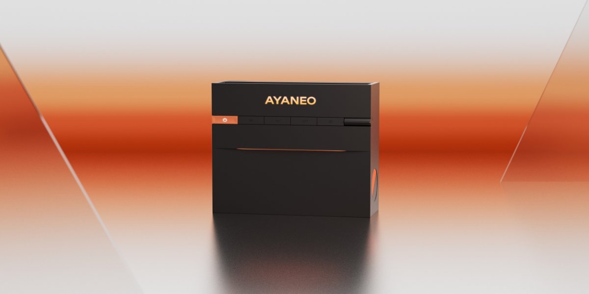 Czarny mini PC z logo \'AYANEO\' na przednim panelu, umieszczony na tle w odcieniach pomarańczowego i szarego gradientu.